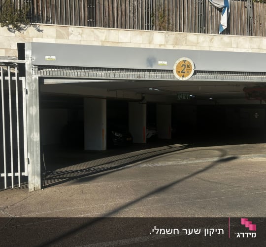 שער חניה חשמלי פתוח עם שלט גובה